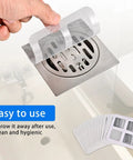 Installing Fifty Pack Disposable Drain Sticker Hair Catcher That Hits Different With Heavy Duty Mesh over a sink drain.
