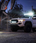 White truck illuminated by 12 Inch 300W Triple Row LED Light Bar Flood And Spot Combo With 30000LM For Driving Off Road Boat And Trucks.
