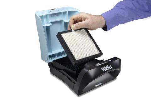 Hand inserting EPA E10 Particulate Filter With Activated Carbon Granules For Gas For Zero Smog Shield Pro into benchtop unit.