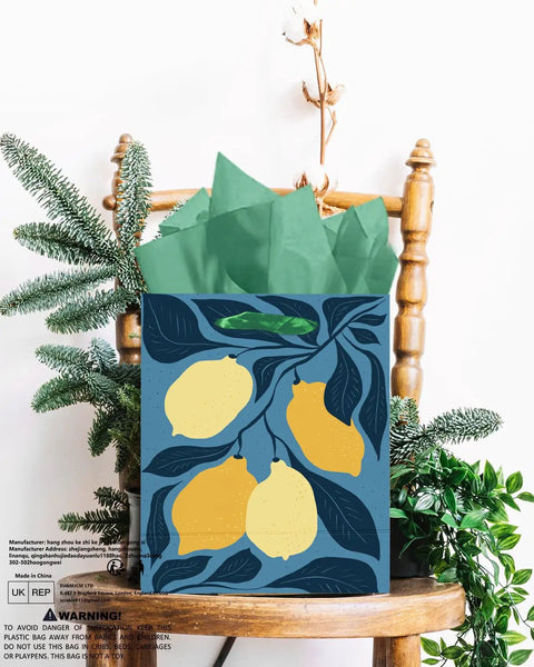 Gift bag with lemon design and green tissue on chair, size 2.4x4.7x6.3 inches, recyclable cardboard, clashing floral theme.