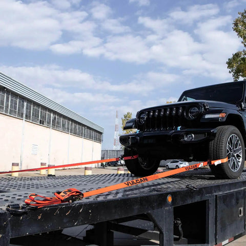 Beefy Pro Series 2 Inch Ratchet Strap with Wire Hooks securing a vehicle on a flatbed, optic orange webbing visible.