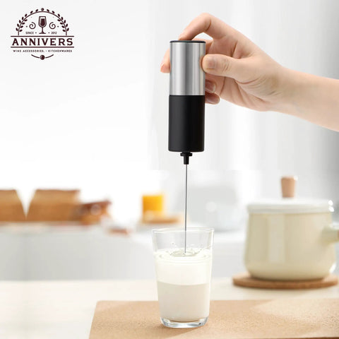 Handheld Electric Milk Frother And Drink Mixer creates rich creamy foam in seconds, stainless steel whisk over a glass of milk.