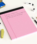 Pink Legal Pad 8.5 X 11 Wide Ruled Writing Pad Set With Perforated Backing 30 Sheets Per Pad on a desk with pens and clips