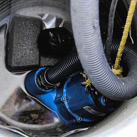 Automatic Cast Iron Sump Pump 115V One Half HP 4300 GPH With Tethered Switch For Residential Basements And Emergency Water Removal Heavy Duty Reliable Performance In Blue Finish inside a water-filled sump pit, showing blue casing and hose connections.