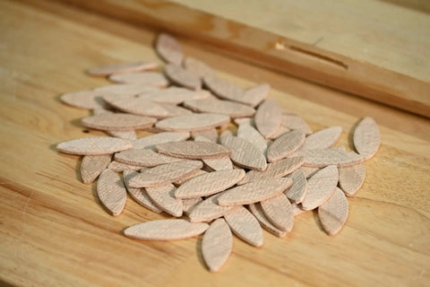 Wood Biscuits No 20, 2-1/4 Inch Long, 50-Piece Pack of durable hardwood biscuits spread on a wooden surface.