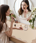 Woman applying makeup on desk with Extra Large PU Leather Desk Pad With Scalloped Edges, Waterproof Non Slip Desk Protector Mat For Office And Home, Large Mouse Pad With Stitched Border, Beige Tone For A Calm, Modern Workspace