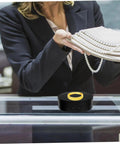 Compact Electric Rotating Turntable Stand For Jewelry Display on a counter, showcasing a gold ring with pearl necklaces.