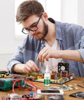 Liquid Flux Soldering Paste 50ml For Electronics DIY and PCB Assembly used by a technician for repair work on a circuit board
