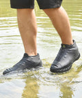 Person wearing Silicone Waterproof Shoe Covers With Zipper, Reusable Rain Overshoes in water, showcasing non-slip tread, Size L