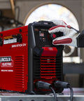 Person using Weld Pak 225i Dual Voltage Stick and TIG Welder 120V 230V, 10 to 225 Amp Output, Lightweight 20 lb Inverter in a garage.