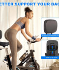 Woman using indoor exercise bike with extra wide bike seat and backrest for support. Focus on cozy cushioned saddle for comfort.