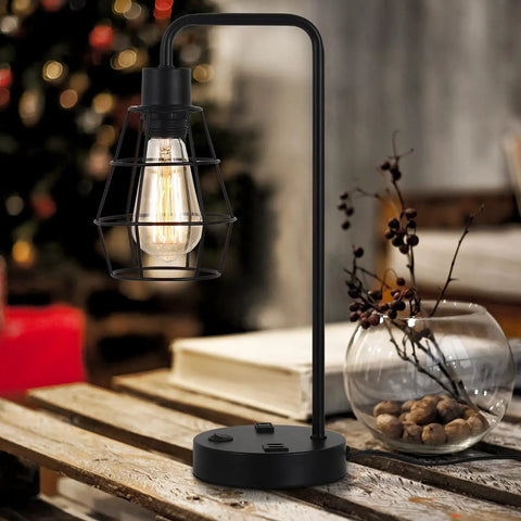 Two Pack Industrial Table Lamps With Dual USB Ports And AC Outlet, Black Metal Cage Shade on wooden table, cozy room setting.