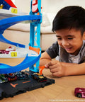 Child playing with Two-In-One City Race Track Set With A Transforming Race Tower From Single Lane To Dual Lane Speedway Includes A Kid-Powered Elevator And 1 Car Amazon Exclusive Toy Playset For Kids.