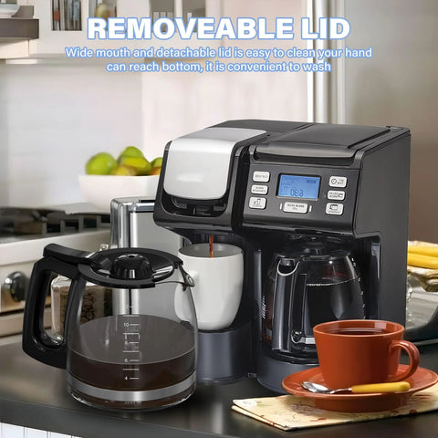 Replacement 12-cup glass coffee carafe with black handle, front view beside the coffee maker's own carafe.