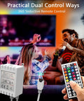 Hands holding 44-key remote controller for LED Lights For Bedroom 50 Feet RGB Color Changing Strip Kit in indoor setting.