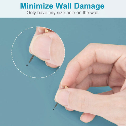 Hand inserting tiny pin into wall with minimal damage, showcasing Solid As A Rock 10 Piece Heavy Duty Picture Hangers And Frame Hooks Supporting Up To 100 Pounds For Mirrors Clocks Wall Art With Stealth Mounting Nails That Keep Your Drywall Looking Crisp Zero Hassle Guaranteed.
