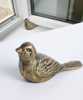 Cast Iron Bird Door Stopper Set 2 Heavy Duty No Drill Floor Door Stops with Handle Antique Bronze Finish for Office Home Bedroom and Exterior Doors Rustic Vintage Decor, close-up view of bird-shaped stopper on floor.