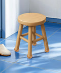 Wooden stool with round legs on blue tiles, adjacent to slippers. Four Pack Wood Furniture Leg Replacement Set Round Bun Feet For Sofa Coffee Table Cabinet And Bench Easy Install Paintable Finish Modern Style Upgrade For Home Decor And Furniture Makeover.