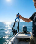 Person holding the Outboard Engine Flush Kit With Rubber U Bend Muff And Quick Attach Hose Interface on a boat.