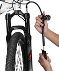 Person using Dope High Pressure Shock Pump For Fork And Rear Suspension 300 PSI Max Lever Lock Nozzle Reduces Air Loss Schrader Valve Compatible For MTB Shocks Black on mountain bike