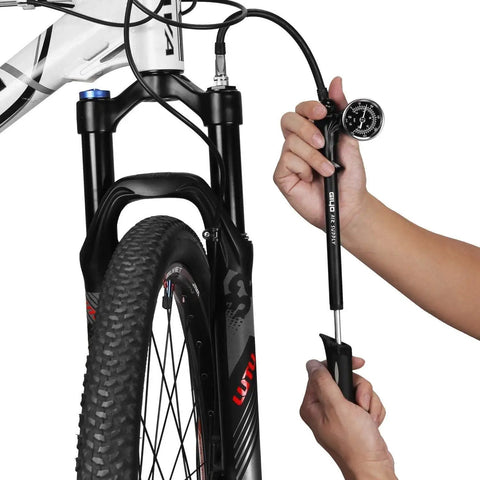 Person using Dope High Pressure Shock Pump For Fork And Rear Suspension 300 PSI Max Lever Lock Nozzle Reduces Air Loss Schrader Valve Compatible For MTB Shocks Black on mountain bike