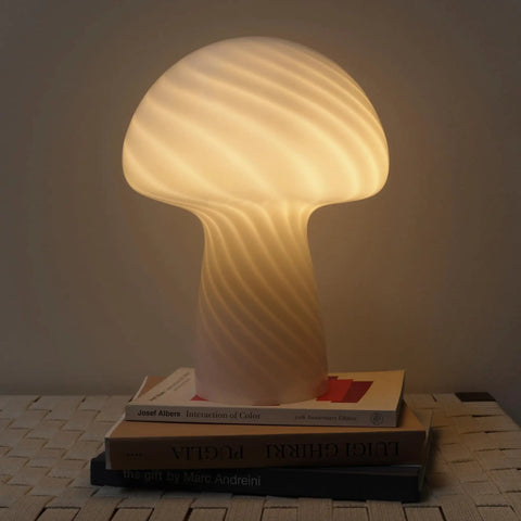 Mushroom Glass Table Lamp 12.75 Inch For Bedside Tables And Desks, glowing warmly on books with subtle glass twist design.