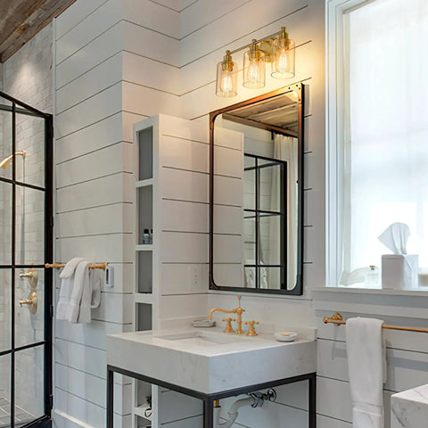 Farmhouse style bathroom vanity light fixture with champagne gold finish and clear glass shade over sink, E26 base.