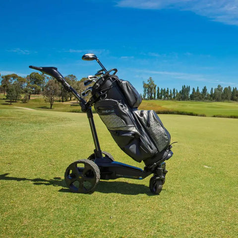 Slick Remote Controlled Electric Golf Push Cart Bundle With Top Shelf Touchscreen Gps Navigation And Preloaded Courses For Thirty Six Holes With Built In Drink Holder And Compact Umbrella Mount Plus Badass Travel Carry Bag on green golf course.