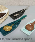 Boat Shaped Coffee Spoon Rest With Turquoise Accent And Matching Mini Spoon Cute Dope Coffee Bar Accessory For Your Coffee Station Or Tea Setup Holds Teaspoon Keeps Counter Clean 1 Piece shown with multiple spoons and coffee beans.