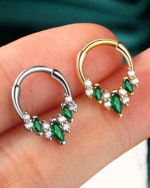 Silver and gold V-shape septum rings with green and white stones on a finger for Blue CZ V Shape Septum Ring 16G Stainless Steel Helix Daith Piercing Jewelry For Everyday Wear Dope Style Lightweight And Comfortable Hypoallergenic Nose Ring