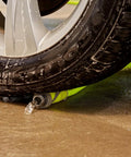 Top Tier 5 8 Inch By 75 Foot Garden Hose With Swivel Grip Connectors underneath a car tire, demonstrating durability against crushes.