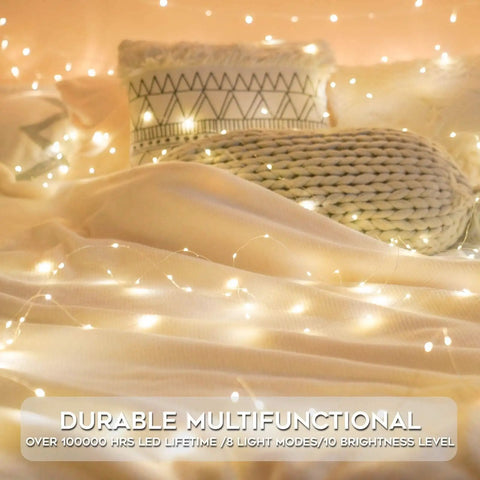 Cozy bedroom setup with Grab These Super Cool Battery Operated Fairy Lights With Remote For Your Holiday Setup Featuring 33 Feet Of 100 LED Dimmable Twinkle String Lights Complete With Timer Waterproof Copper Wire Ideal For Bedroom Christmas Tree And Indoor Outdoor Decor In glowing softly over blankets and cushions.