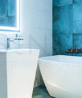 Bathroom with Three Handle Matte Black Tub And Shower Trim Kit For Pfister Faucets against a blue tiled wall.