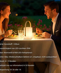 Couple dining outdoors by Cordless LED Lantern Table Lamp With Remote, IP44 shower safe and waterproof, on patio table at night
