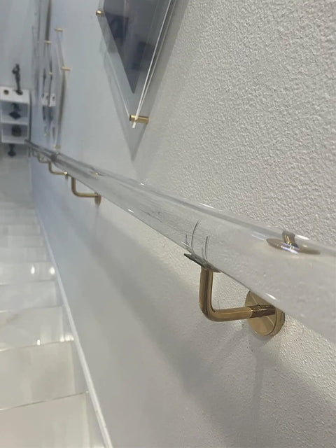 Custom Clear Acrylic Stair Handrail With Premium Gold Wall Brackets For Heavy Duty Indoor Exterior Support Featuring A Kickass Non Slip Grip And No Sweat Installation, angled view showing wall brackets.