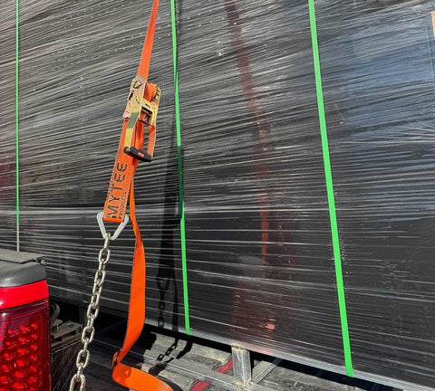 4 Pack 2 Inch Orange Ratchet Straps With Chain Anchors 4000 Lbs WLL securing a black load on a truck bed