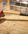 A hand gripping a wooden handle of a tool, preparing for repairs with Heavy Duty Waterproof Polyurethane Glue In Rich Brown.