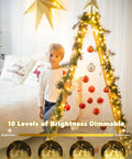 Child with a triangular tree decorated with 78Ft 240 LED Fairy Lights Battery Operated With Timer And Remote, indoors.