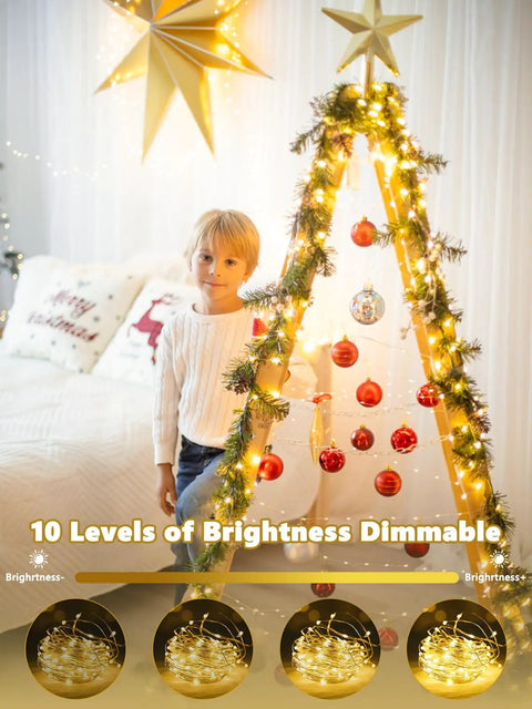 Child with a triangular tree decorated with 78Ft 240 LED Fairy Lights Battery Operated With Timer And Remote, indoors.