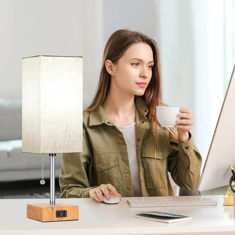 Set Of 2 Wood Table Lamps For Bedroom With 3 Color Modes Warm White Soft White Daylight White Pull Chain Nightstand Lamps With AC Outlets Compact Bedside Lights With 2 Bulbs For Living Room Kids Room Office Decor shown on office desk with woman working on computer.