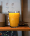 Rock Bar 16.25 Oz Cooler Glass with orange juice on shelf, part of stackable tempered glass set for cocktails at home bars