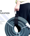 Person holding a coiled hose with a Two Pack Heavy Duty Cord Storage Wrap Holder, black hook and loop strap visible.