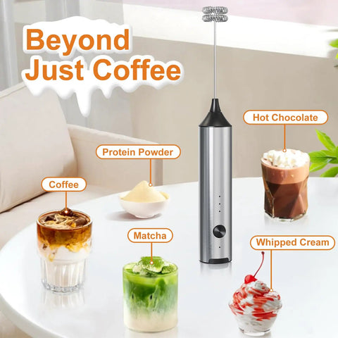 Rechargeable Handheld Milk Frother With Stainless Steel Stand Three Speeds Electric Milk Whisk For Latte And Cappuccino Cordless Coffee Mixer With Type C Charging Easy One Touch Frothing For Barista Quality Drinks on a table with drinks.
