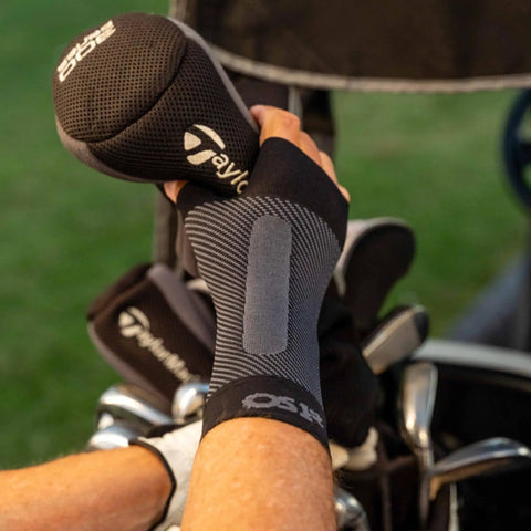 WS6 Compression Wrist Sleeve for Carpal Tunnel Relief, breathable fabric, worn during golf activity, provides steady wrist support.