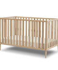 Mia Toddler Rail For Convertible Crib In Natural Wood Safe Transition Guardrail JPMA Certified shown on crib base, no tools required