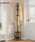 Black Coat Rack Stand With Umbrella Holder Freestanding 16 Hook Coat Tree in corner of room holding hats, umbrellas, and bags.