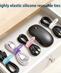 Ultimate 76 Piece Cable Organizer Set with silicone ties securing various cables in a drawer near a mouse