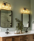 Black And Gold 3 Light Vanity Light Fixture Over Mirror With Clear Glass Shade For Bathroom, wall-mounted above mirrors.