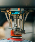 Close-up of backpacking stove flame from Camping Cookware 18 Piece Mess Kit With Backpacking Stove, durable and compact.