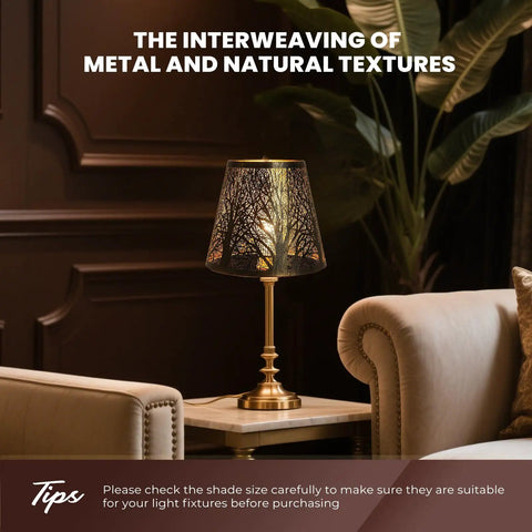 Table lamp with clip-on lampshade on brass base; natural tree design, setting in classic room with armchair and plants.